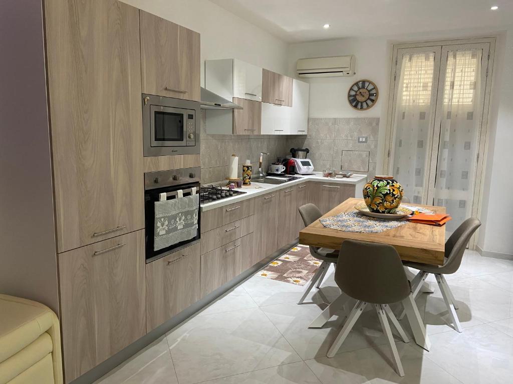 a kitchen with a wooden table with chairs and a tableasteryasteryasteryasteryastery at Casa del pittore in Niscemi