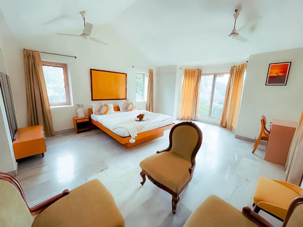 Private Paradise Opposite Nandi Hills في بانغالور: غرفة كبيرة بها سرير وكرسي