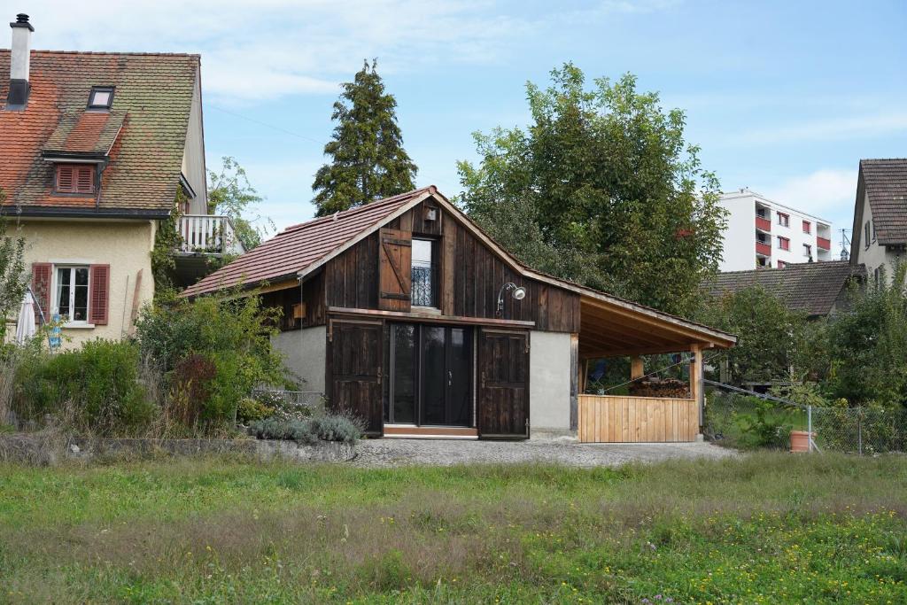 an old house with wooden doors and windows at Tiny House Chez Claudine - Relaxen, Workspace, Nähe Thermen, Netflix, free Parking &amp; Wifi in Brugg