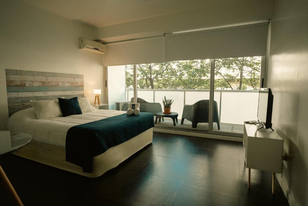 Sucre Suites في بوينس آيرس: غرفة نوم بسرير ونافذة كبيرة