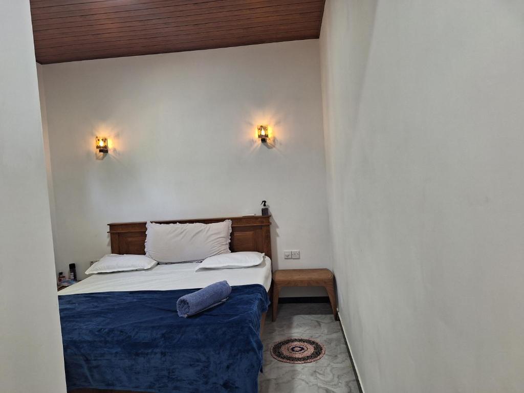 een slaapkamer met een bed en twee lampen aan de muur bij Alali Villa in Bentota