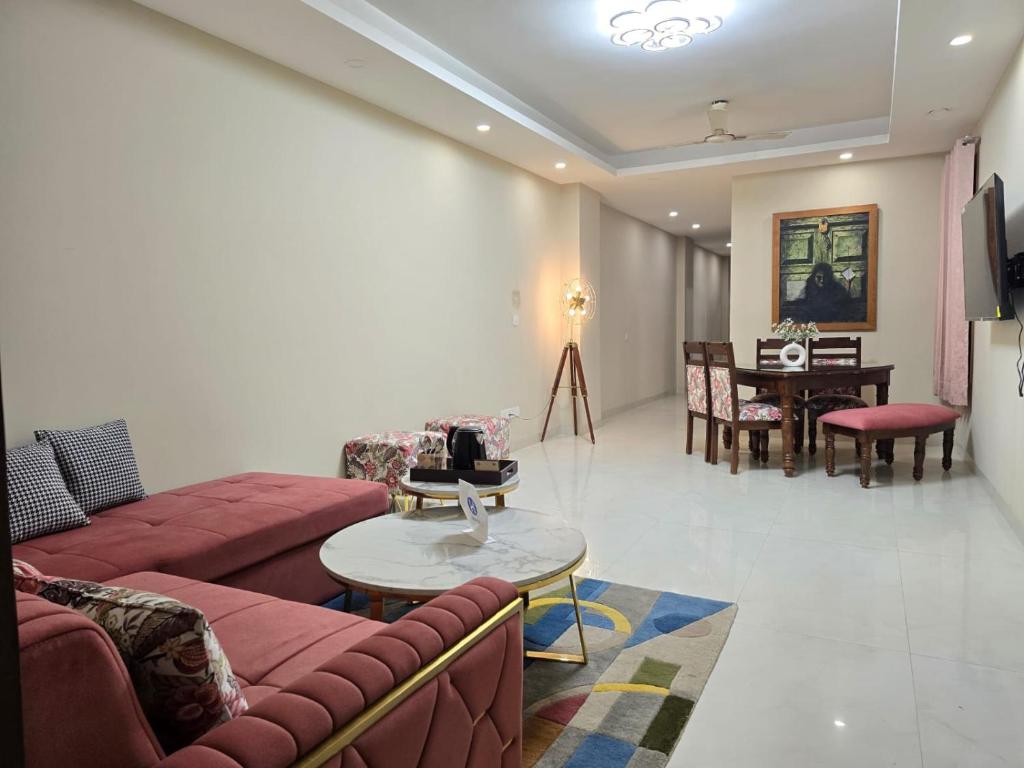 een woonkamer met rode banken en een tafel bij Homlee-Saket Anupam Stylish 3BHK in South Delhi in New Delhi