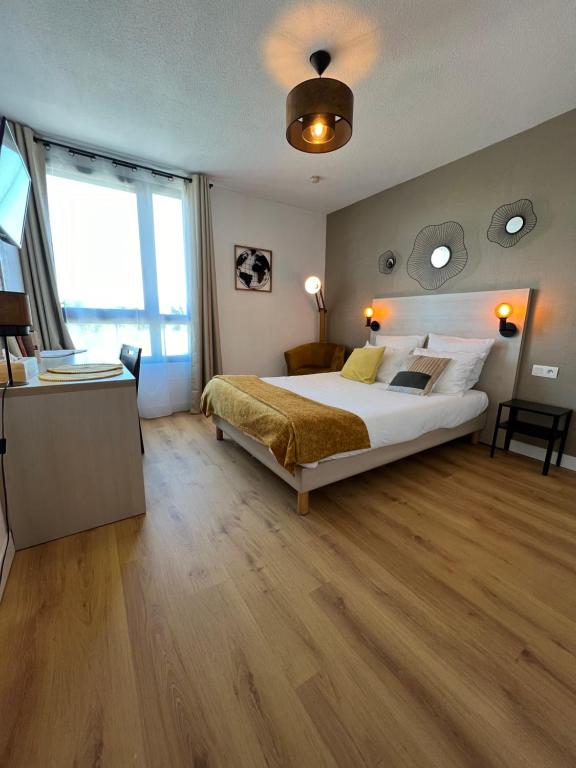 sypialnia z dużym łóżkiem i dużym oknem w obiekcie Appart'Hotel - Gare TGV - Courtine - Confluence - 218 w Awinionie