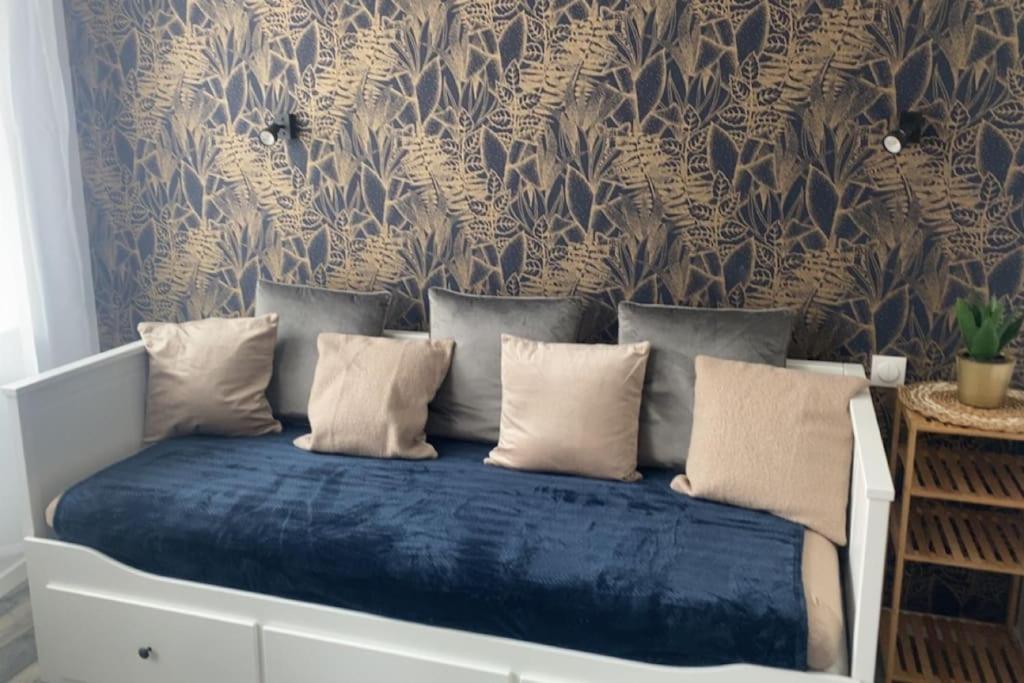 - un lit avec des draps bleus dans une chambre avec un mur dans l'établissement Studio N°2 hyper centre, à Châteaubriant