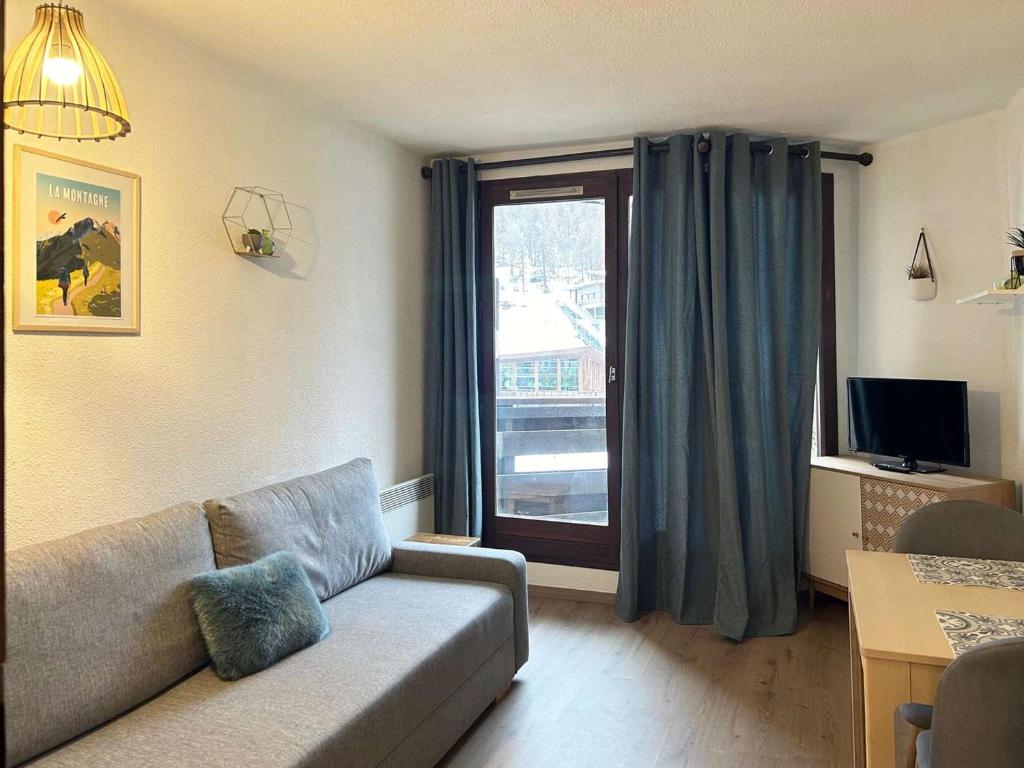 un salon avec un canapé et une fenêtre dans l'établissement Studio central skis aux pieds, 4 pers, balcon - FR-1-322-10, aux Orres