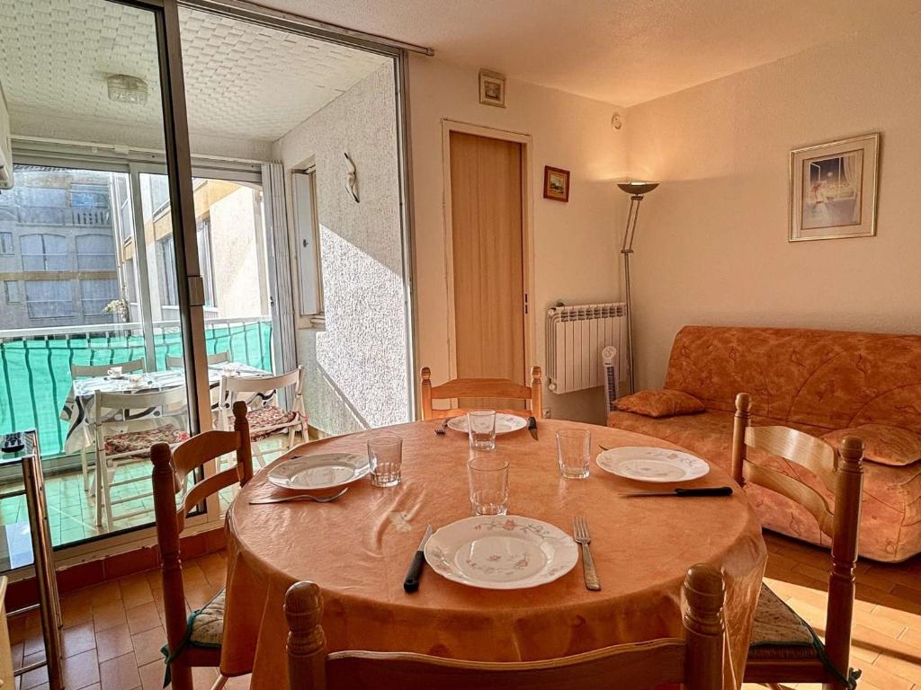 un tavolo in un soggiorno con tavolo e sedie di Appartement Argelès-sur-Mer, 1 pièce, 3 personnes - FR-1-225-634 ad Argelès-sur-Mer