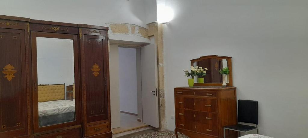 una camera da letto con cassettiera, specchio e armadio di Casa Scarciglia a Minervino di Lecce