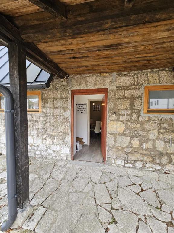 an entrance to a stone building with a wooden ceiling at Sreća Plitvice in Plitvička Jezera