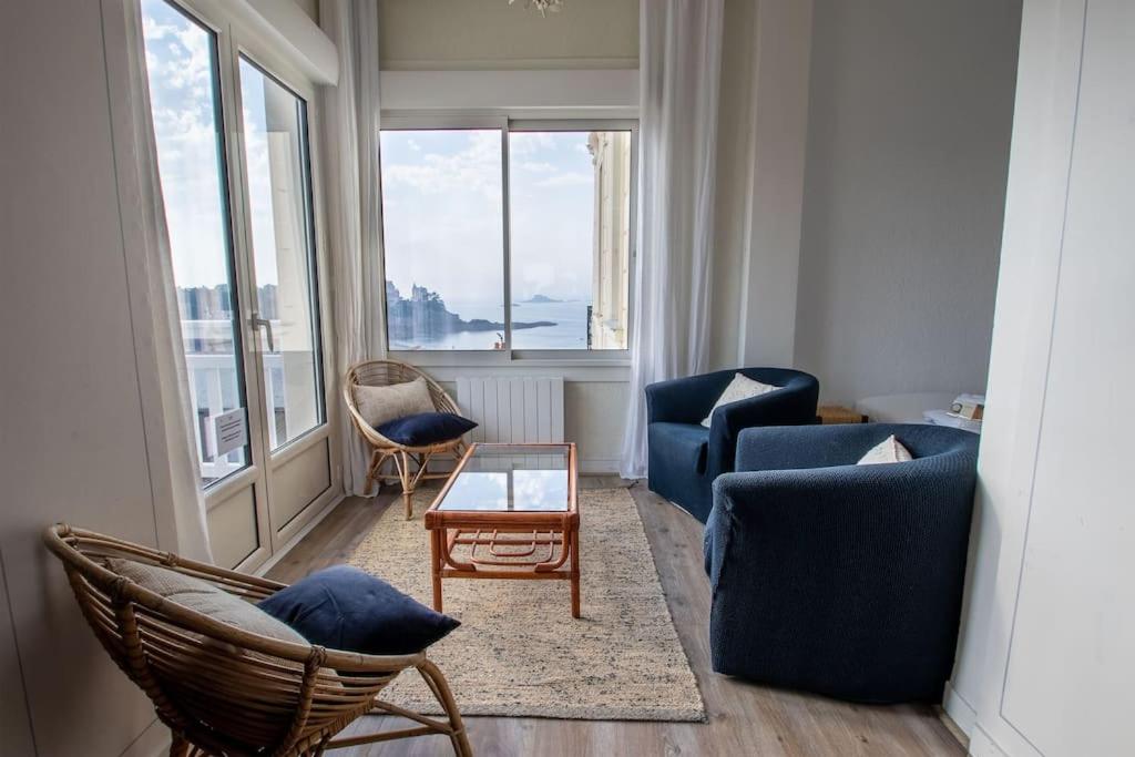un salon avec deux chaises bleues et une table dans l'établissement Bel appartement avec vue sur la baie de Dinard, à Dinard
