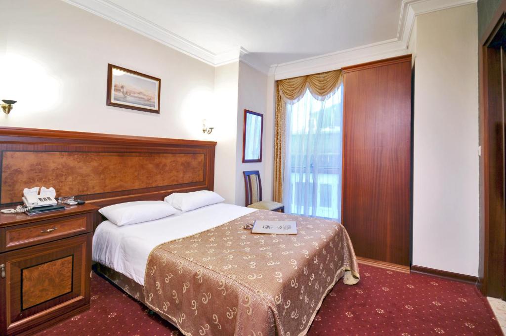 a hotel room with a bed and a window at Grand Eyuboglu Hotel in Istanbul