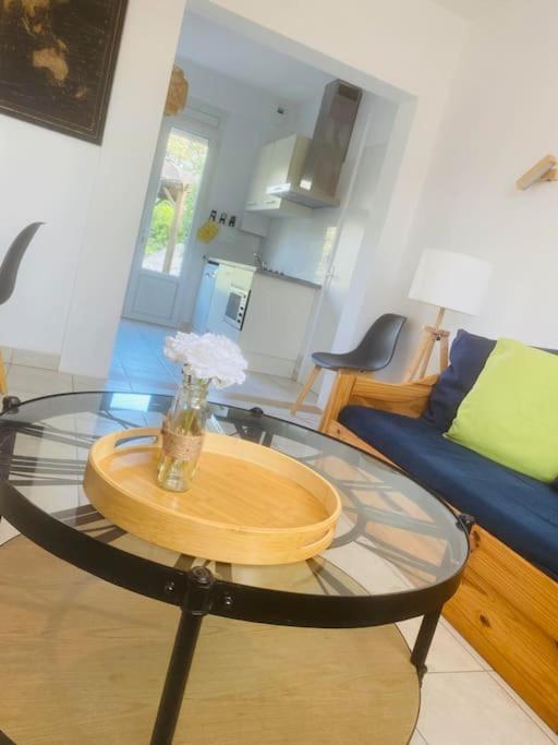 - un salon avec une table en verre et un canapé bleu dans l'établissement Rez-de-chaussée face mer 6 personnes, à Saint-Michel-Chef-Chef