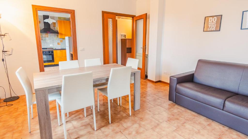 jadalnia ze stołem, krzesłami i kanapą w obiekcie Villa Quantum - Italian Homing w mieście Desenzano del Garda