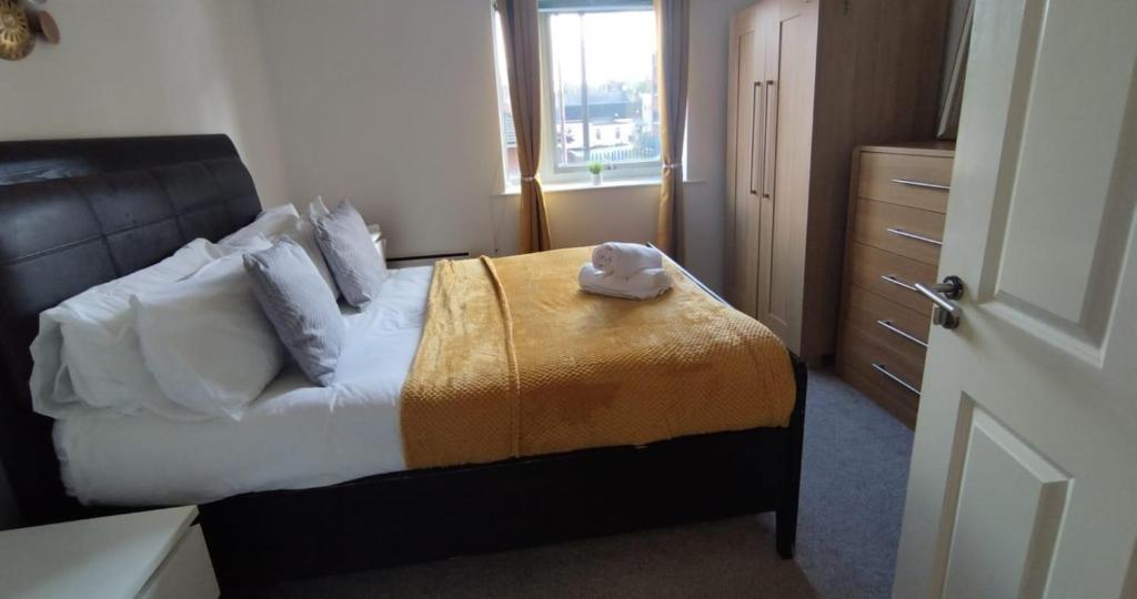 a bedroom with a bed with a hat on it at Business & Leisure City Centre 2 Bed En-suite Apartment with free parking and Netflix in Coventry