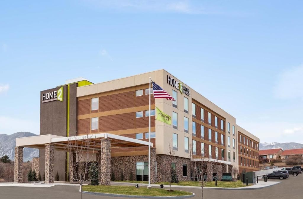 un'immagine di un hotel con una bandiera americana davanti di Home2 Suites By Hilton Colorado Springs Airport a Colorado Springs