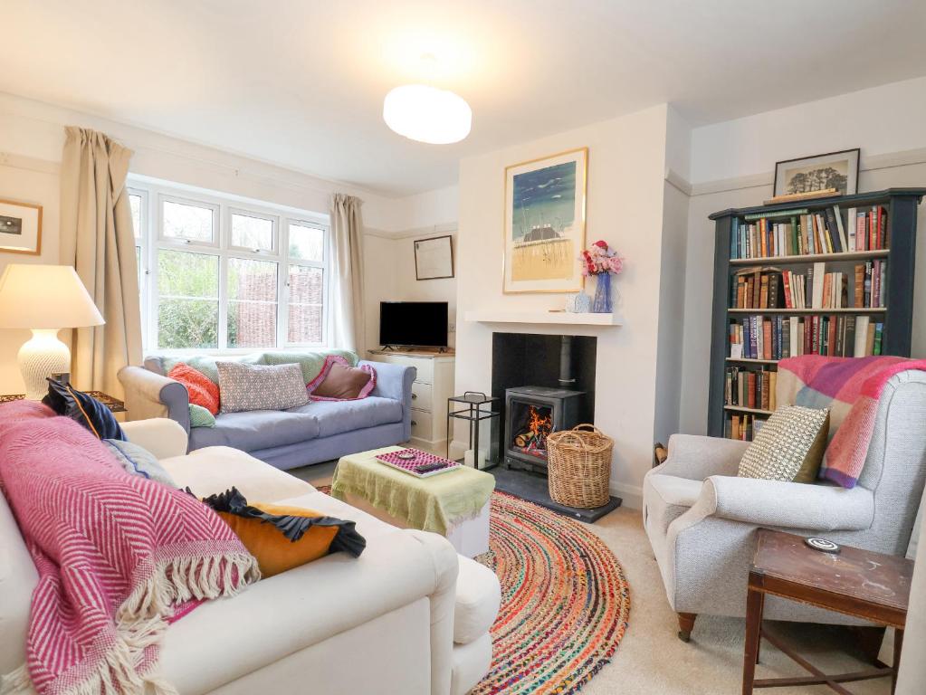 a living room with two couches and a fireplace at 3 Chantry Cottages in Woodbridge