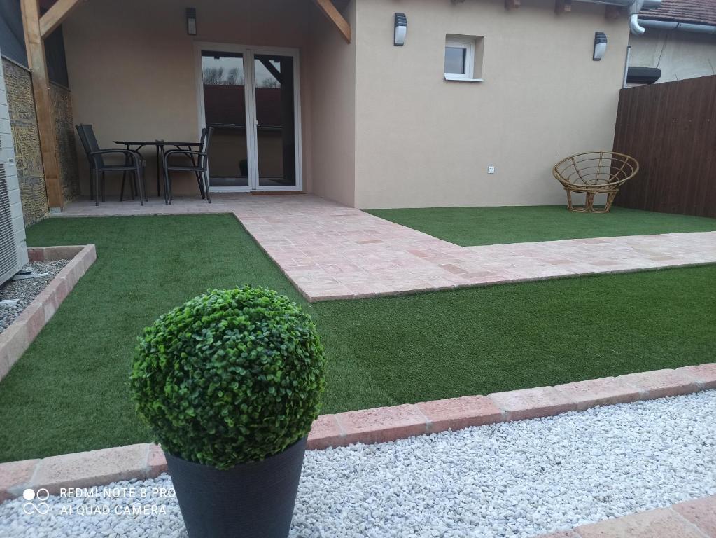 a yard with green grass and a house at ROZINA Vendégház in Balatonederics