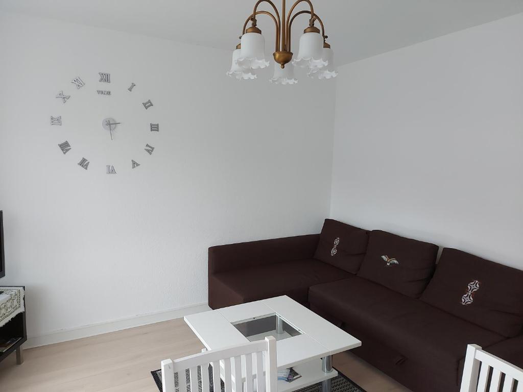 - un salon avec un canapé et un réveil sur le mur dans l'établissement Ferienwohnung Hiddesen, à Detmold