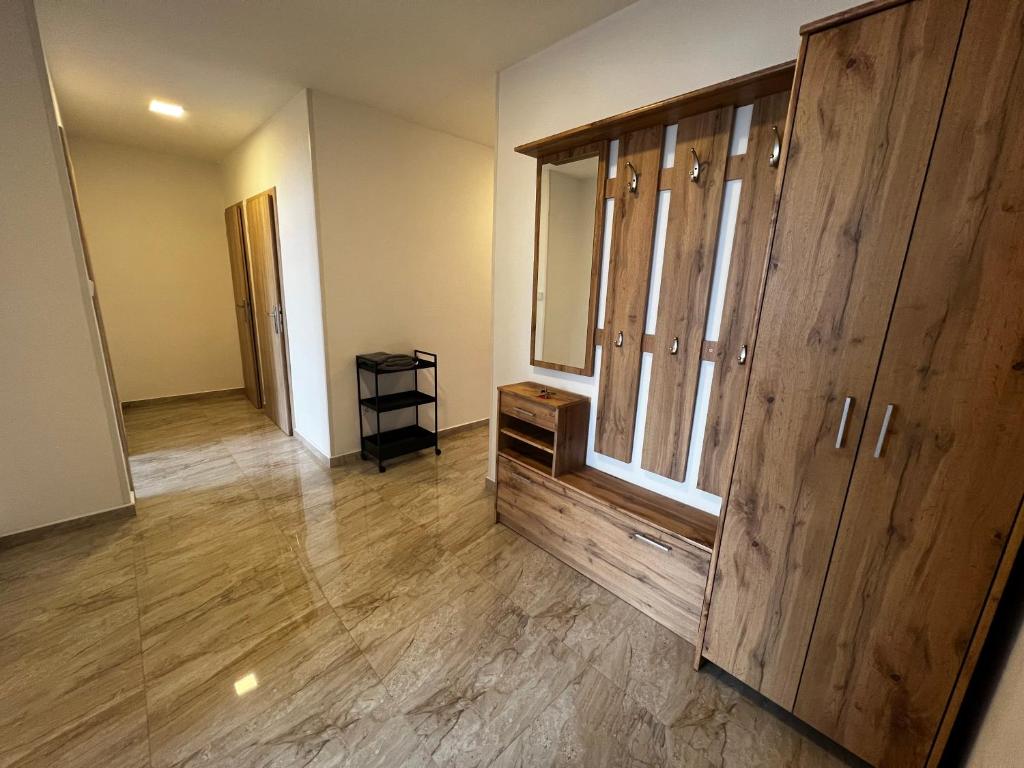 an empty room with a large wooden cabinet and a hallway at Hoa Stay in Prague