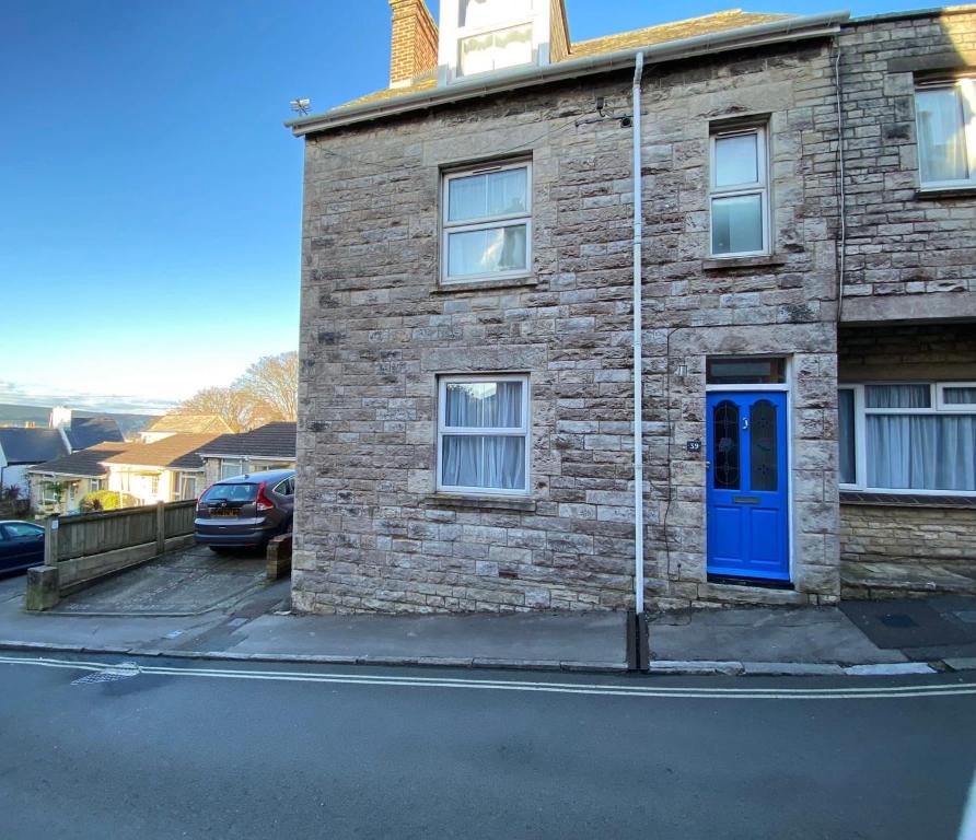 a brick building with a blue door on a street at 39 Queens Road in Swanage