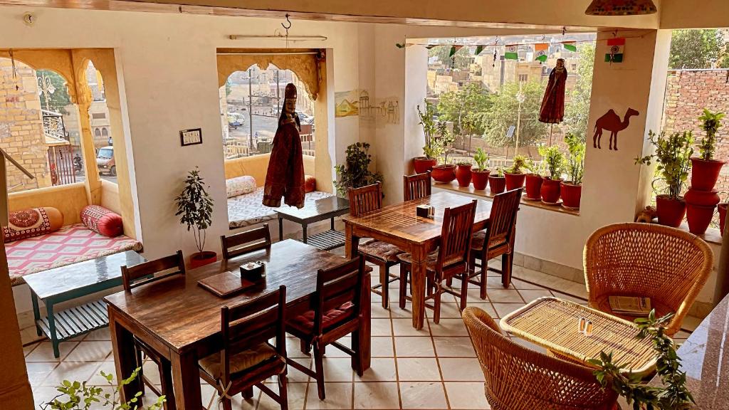 ein Restaurant mit Tischen und Stühlen in einem Zimmer in der Unterkunft The Wanderlust Guest House & Safari in Jaisalmer