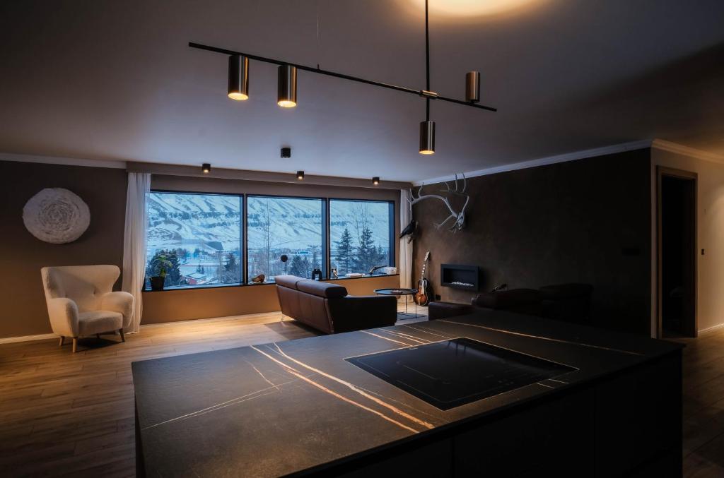 ein Wohnzimmer mit einem Sofa und einem großen Fenster in der Unterkunft Botnahlid Villa in Seyðisfjörður