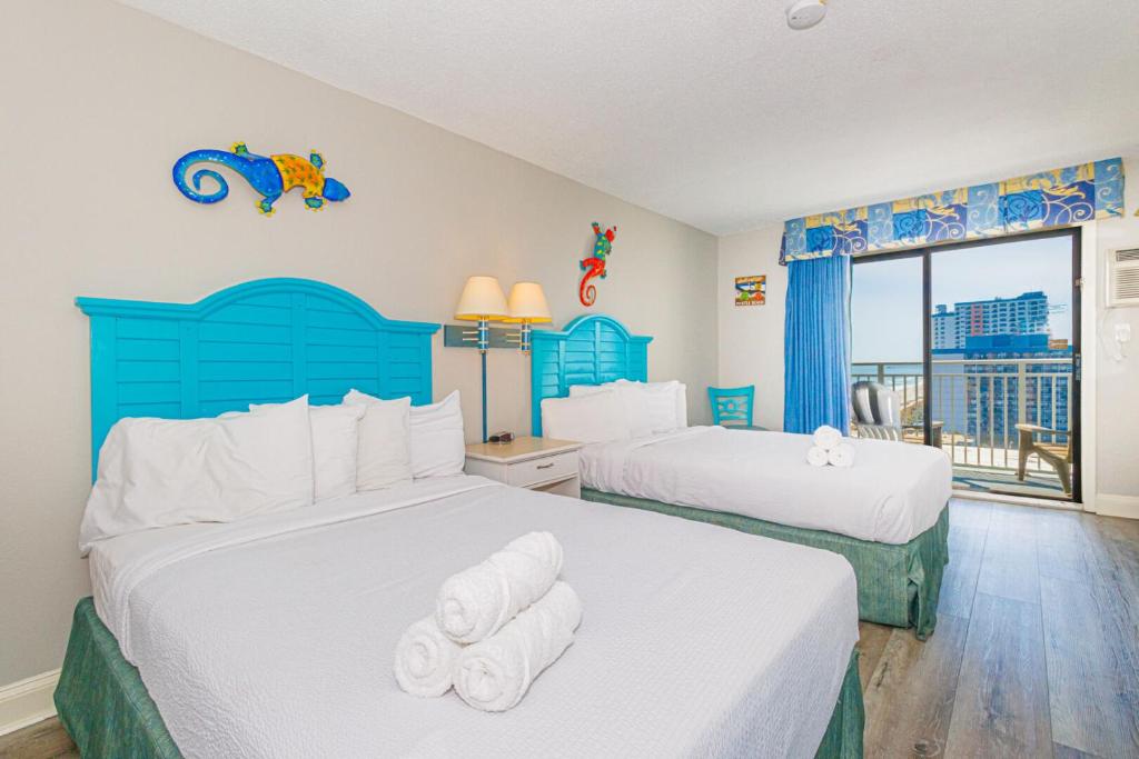 twee bedden in een slaapkamer met een blauw hoofdeinde bij Sea Mist 51405 in Myrtle Beach