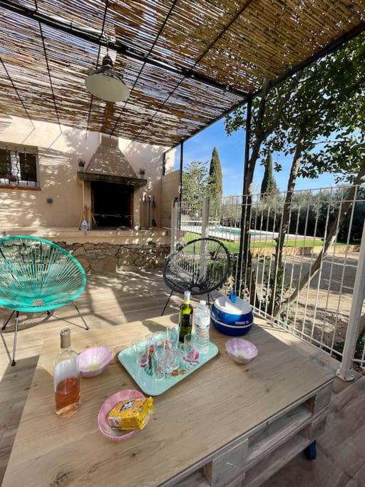 - une table en bois avec de la nourriture et des boissons sur la terrasse dans l'établissement Havre de paix en Provence : maison avec piscine, à Salernes
