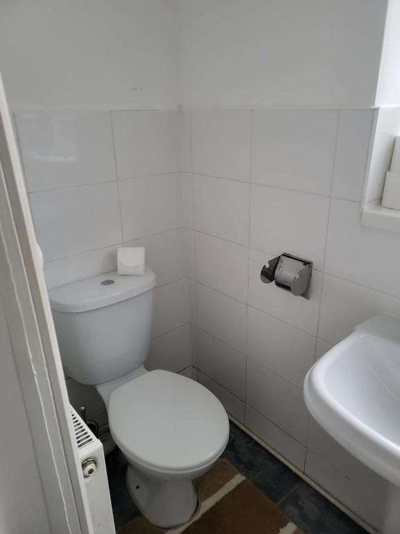 a white bathroom with a toilet and a sink at swagger in Tilbury