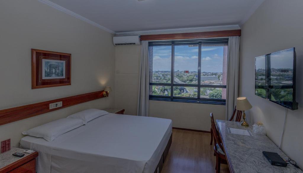 Uma TV ou centro de entretenimento em Lizon Curitiba Hotel