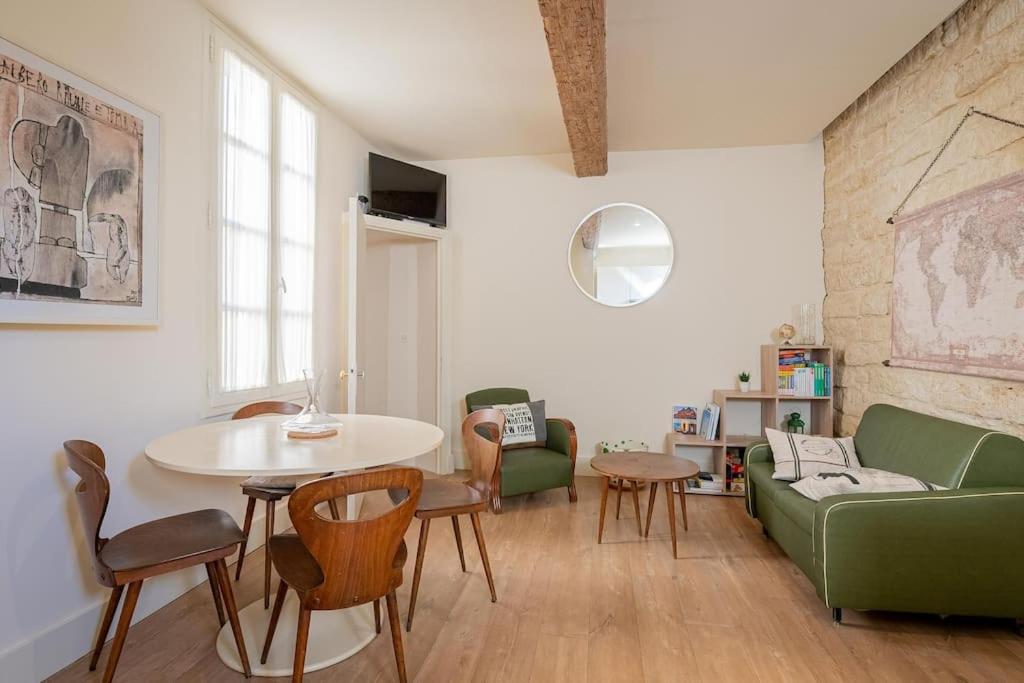 a living room with a green couch and a table at Le petit Saint Jean T2, Clim, Centre historique in Montpellier
