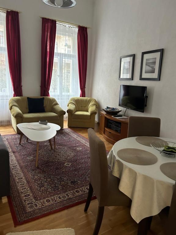 a living room with a table and a tv at Apartment Sadova in Karlovy Vary