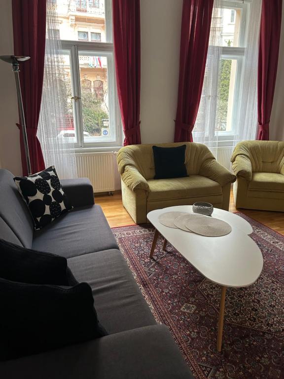 a living room with two couches and a coffee table at Apartment Sadova in Karlovy Vary