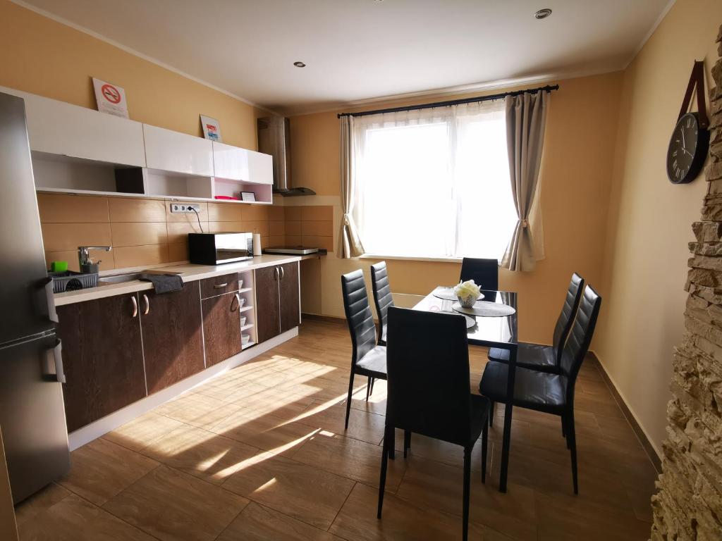 a kitchen with a table and chairs in a room at Korzó Apartman Velence in Velence