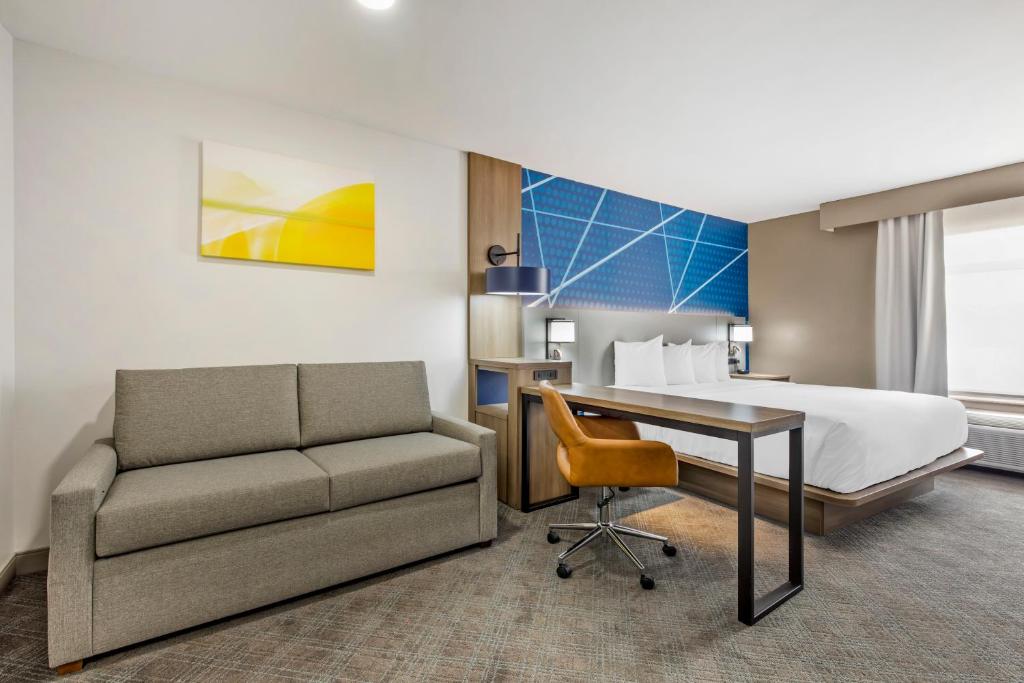 een hotelkamer met een bed, een bank en een bureau bij Comfort Inn & Suites Irving Las Colinas DFW in Irving
