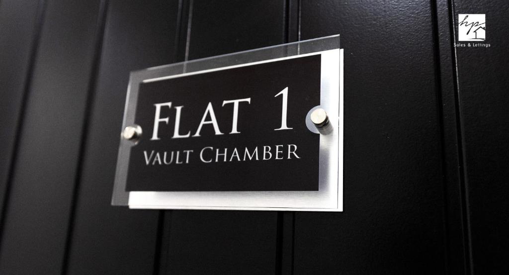 Un cartello su una porta che legge camera a volta piatta di Vault Chambers a Brierley Hill