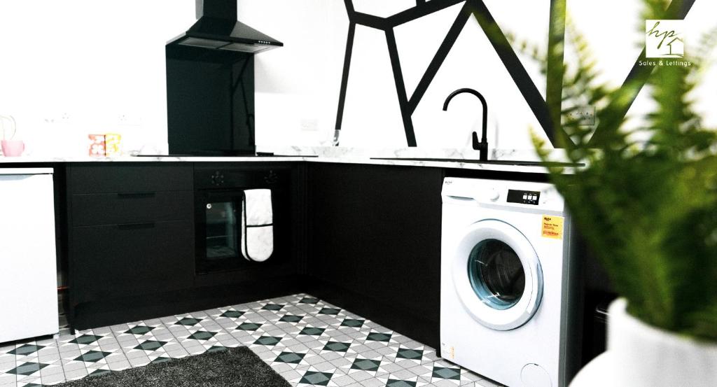 a laundry room with a washing machine and a sink at Credit Corner in Brierley Hill