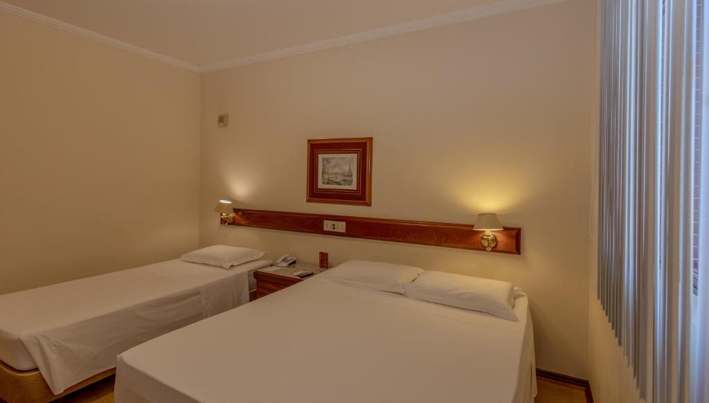 Cama ou camas em um quarto em Lizon Curitiba Hotel