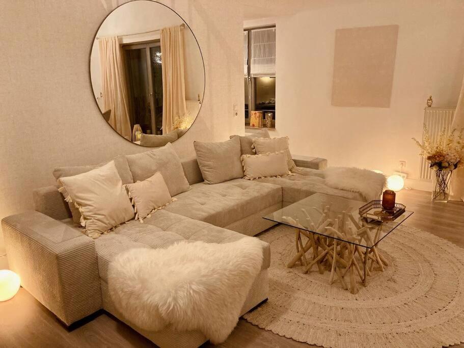 un soggiorno con divano e specchio di AMALFI HOME - Stylish apartment with terrace a Schönefeld