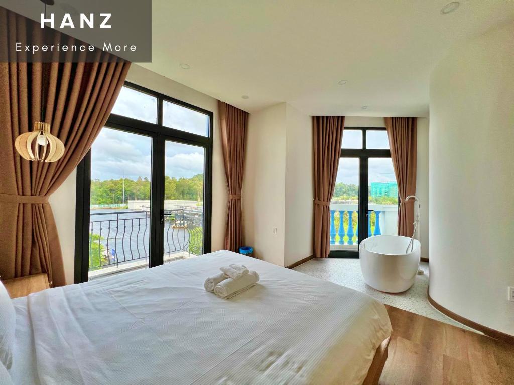 a bedroom with a large bed and a large window at HANZ Sofia Hotel Grand World in Phu Quoc