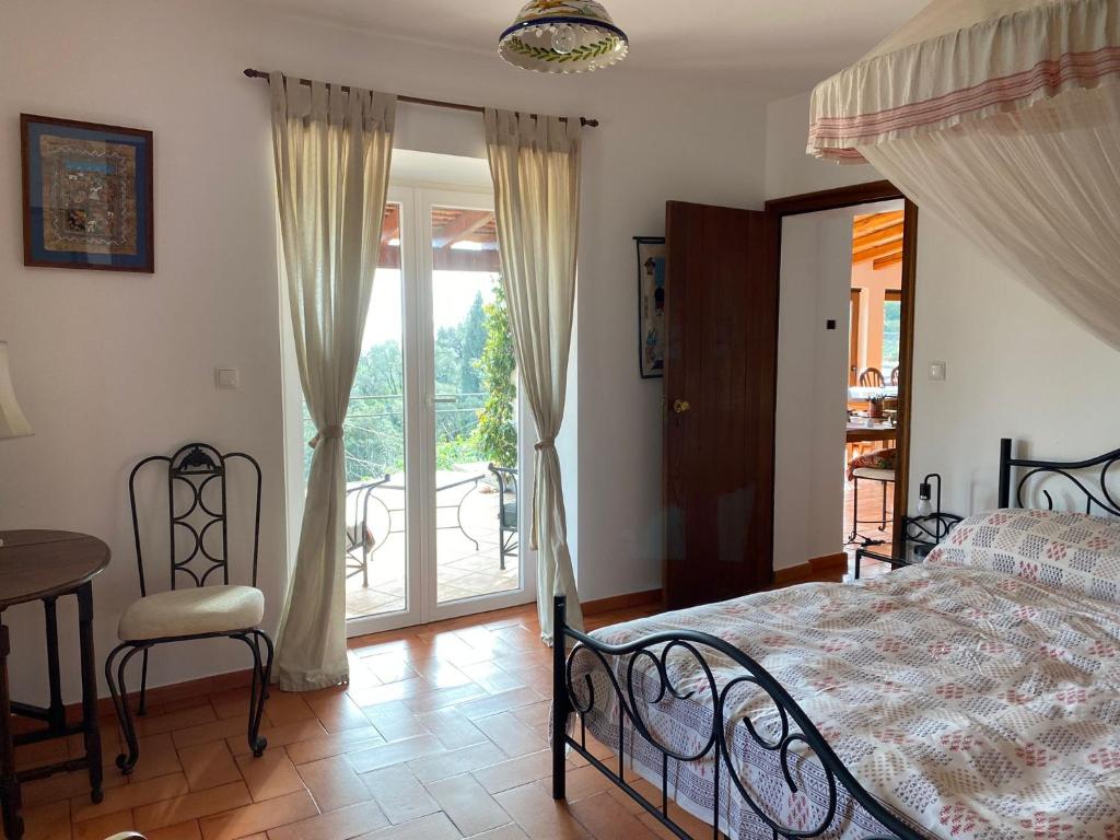 um quarto com uma cama, uma mesa e uma varanda em Corgos, Passaros em Monchique