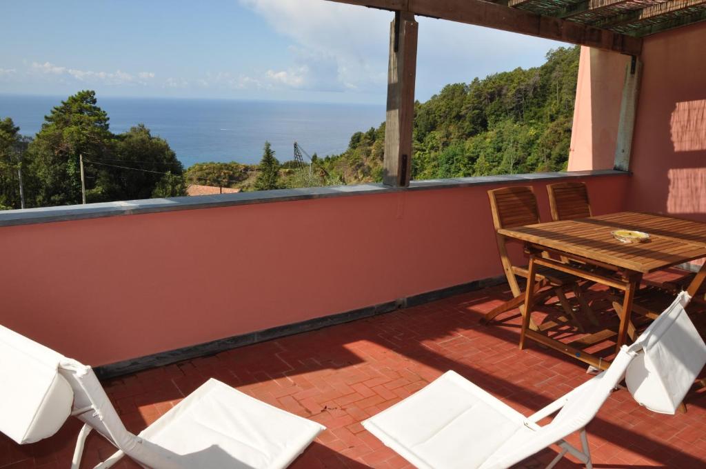 balcone con tavolo, sedie e vista sull'oceano di Rossola House a Bonassola