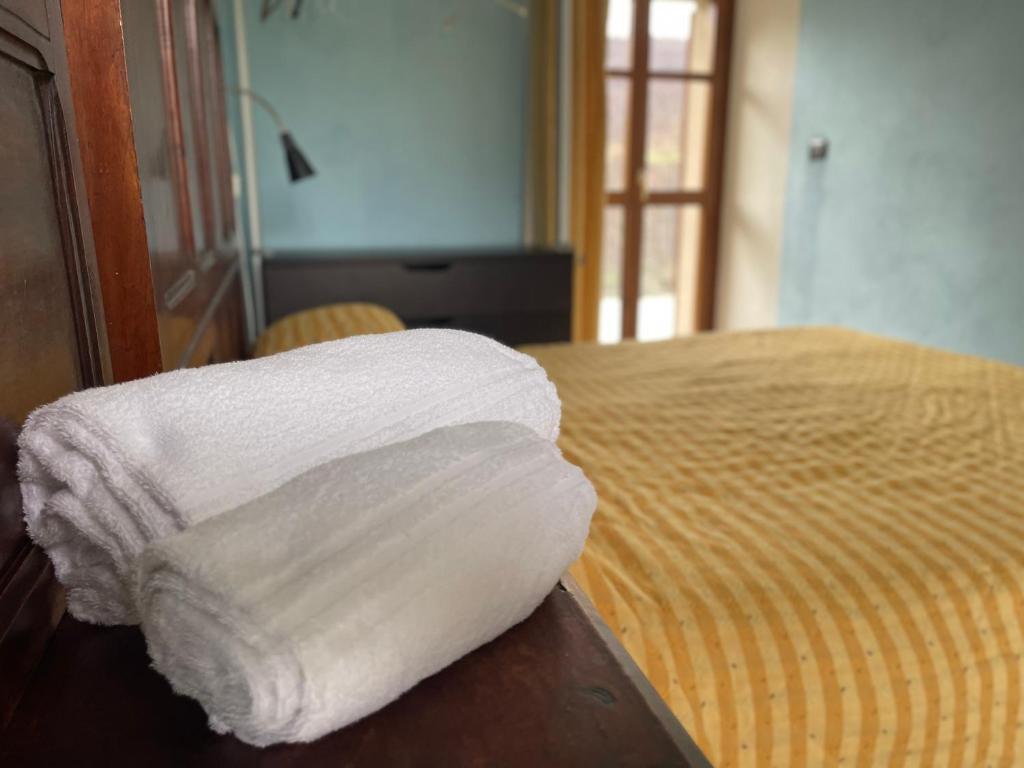 uma pilha de toalhas sentadas em cima de uma cama em Agriturismo Gallo em Cortemilia