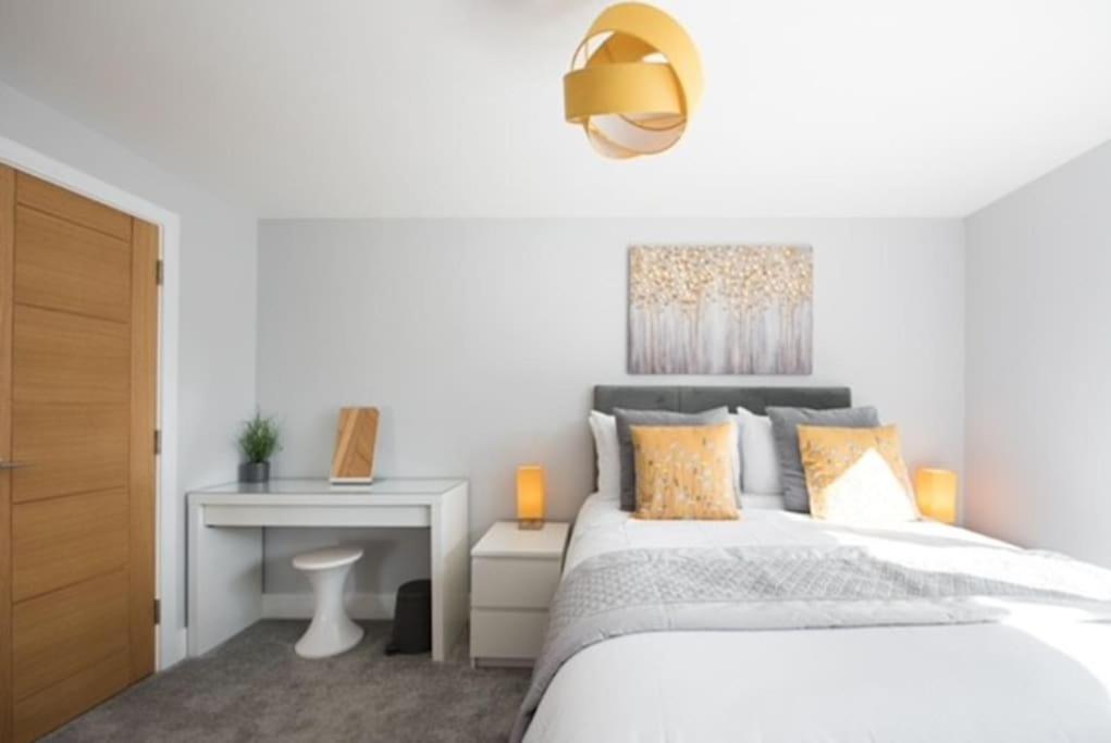 een witte slaapkamer met een bed en een bureau bij Beautiful, Spacious 1 bed flat in Brentwood