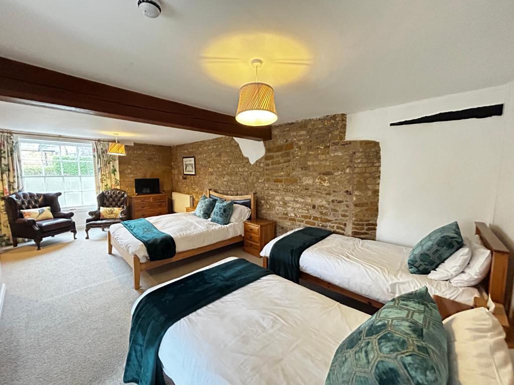 um quarto com 2 camas e uma sala de estar em Kingfisher em Lyddington