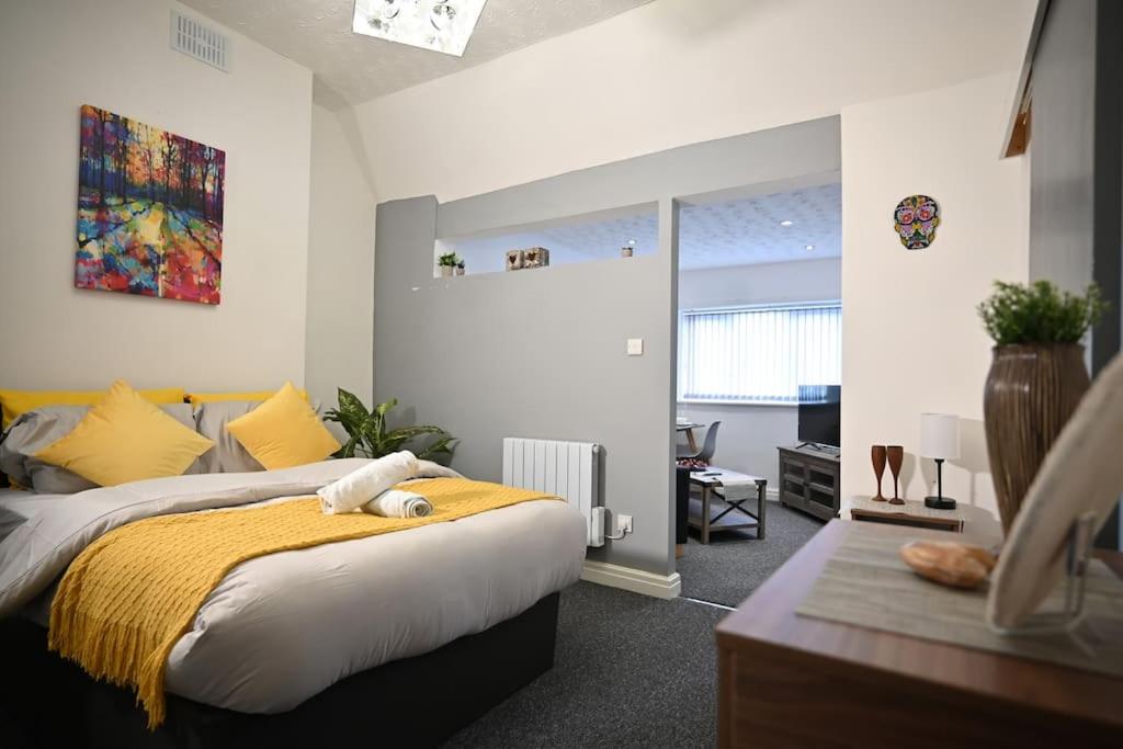 a bedroom with a large bed with a yellow blanket at Bubble Rooms in Manchester