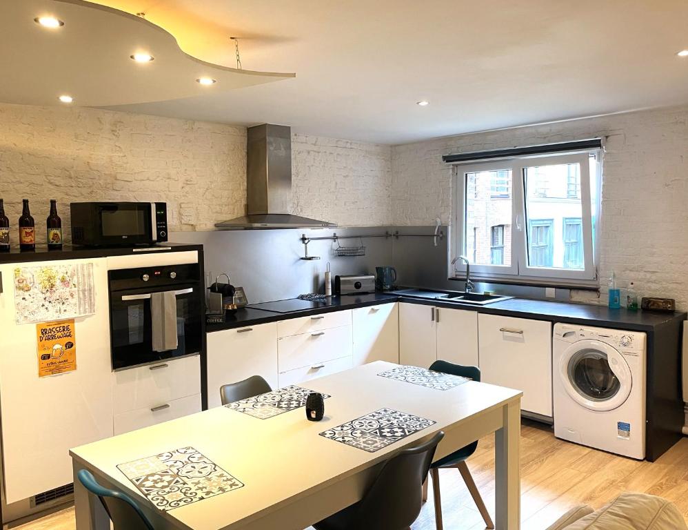 a kitchen with a table and a dining room at Escalille le Royale in Lille