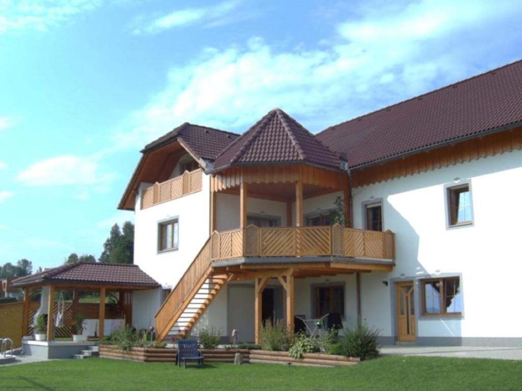 una casa con portico e terrazza di Ferienwohnung Weberschläger a Ulrichsberg