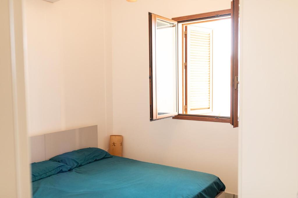 Schlafzimmer mit einem Bett und einem Fenster in der Unterkunft Villa Julia, magia del sud in Sampieri
