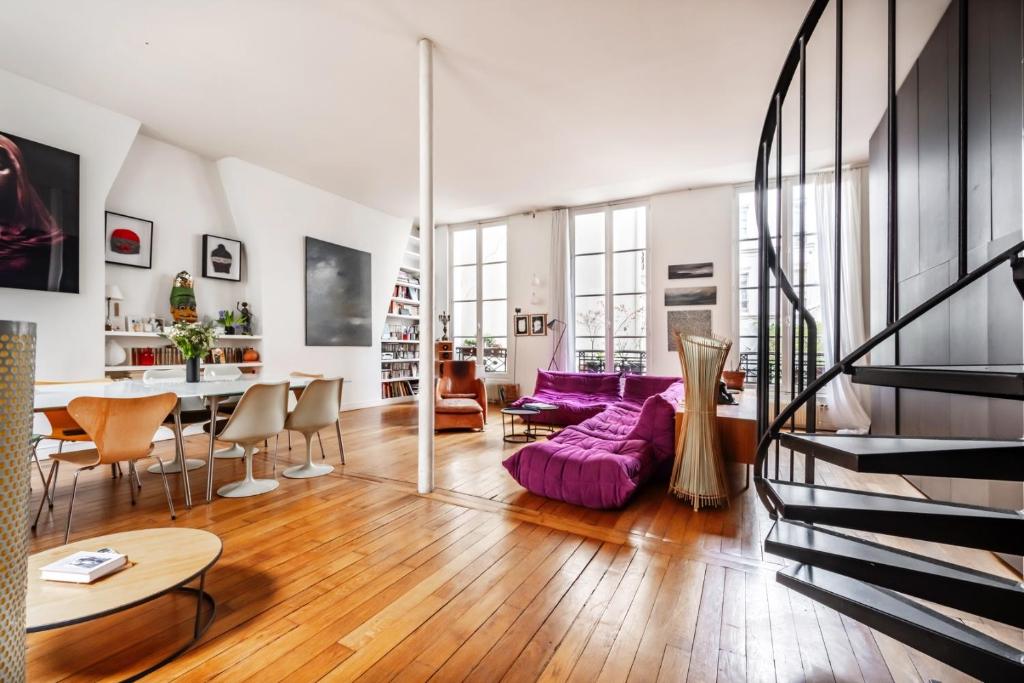 un salon avec un canapé violet et une table dans l'établissement Veeve - Haut Marais Glam, à Paris