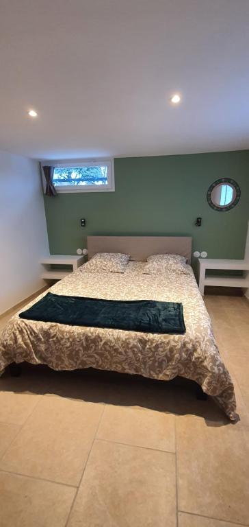 Schlafzimmer mit einem Bett und einem Fenster in der Unterkunft La romarine in Bourg-Saint-Andéol